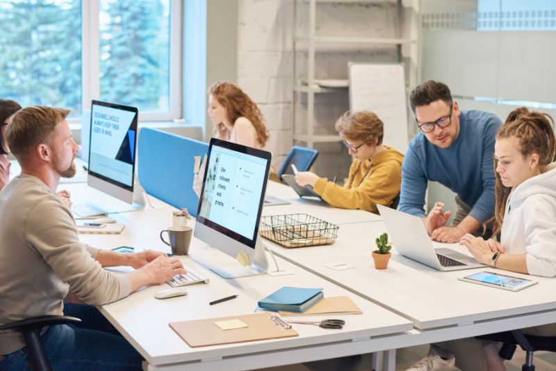 Personas frente a computadoras en una oficina